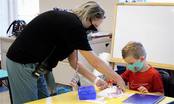 teacher helps student on first day of school